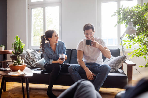 Couple discutant autour d’un café dans un salon lumineux